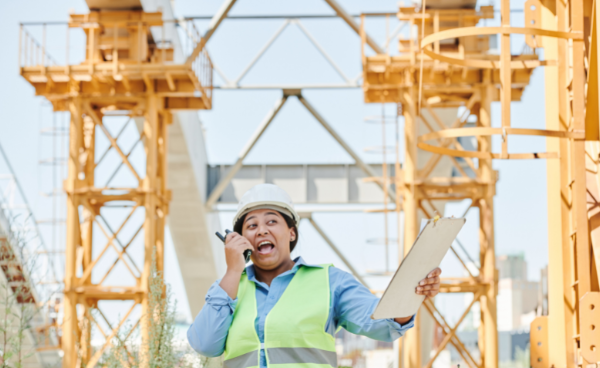 Construction worker speaking through a communication device.