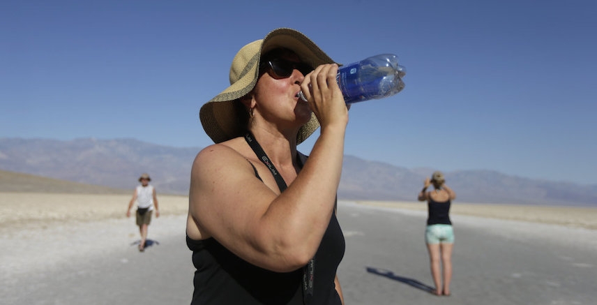 Woman drinks water under extreme heat