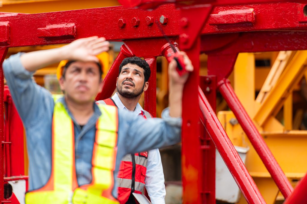 Crane Worker Inspecting Crane on a Construction Site
