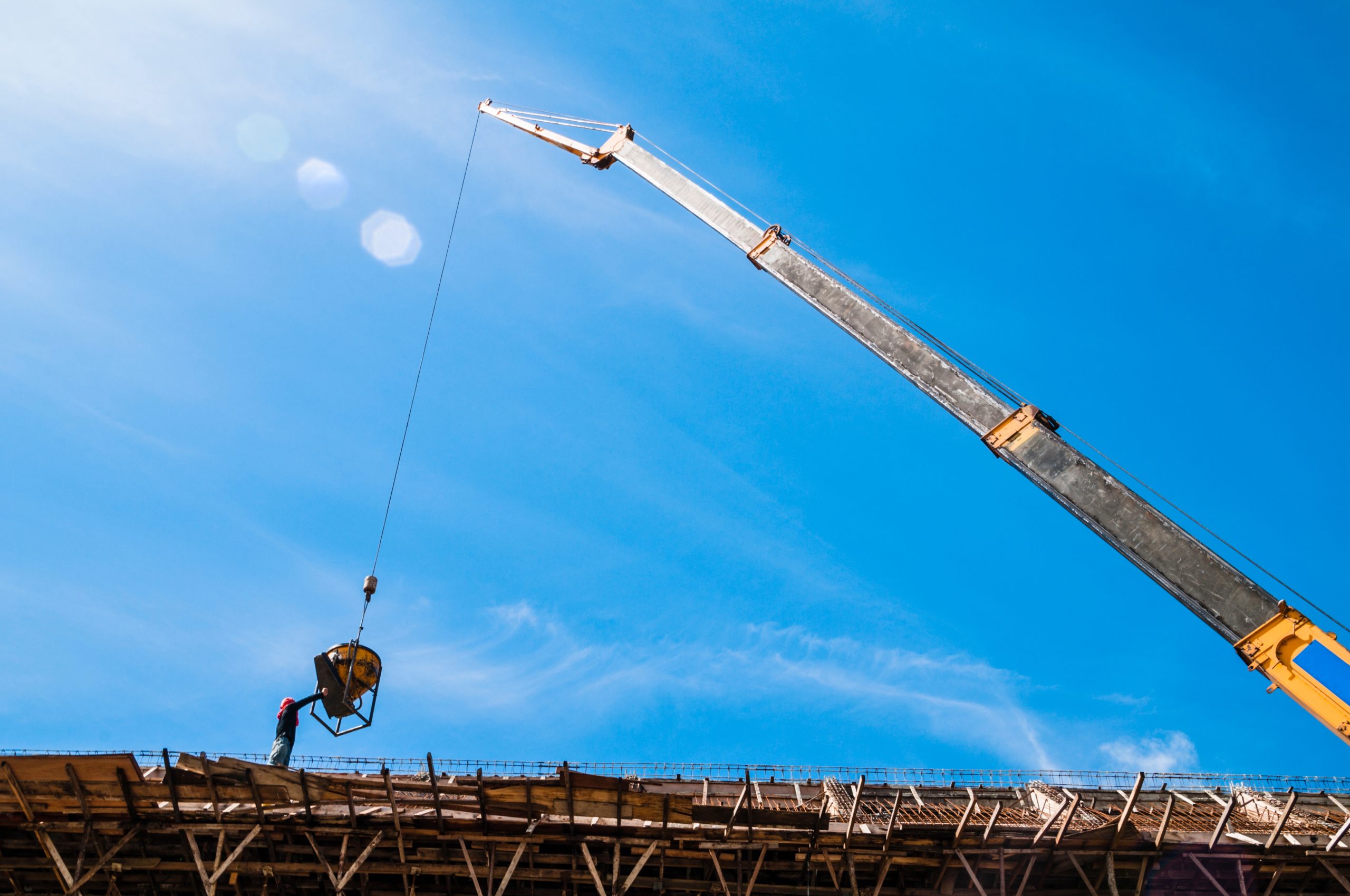 Crane-lifting-a bucket-of-cement-at-a-construction-site