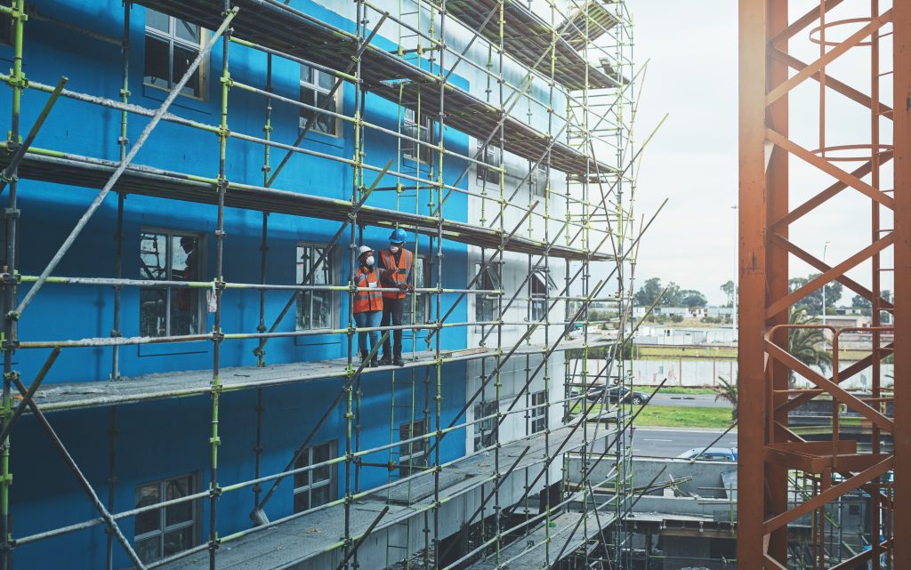 Young-man-and-woman-working-at-a-height-on-a-construction-site